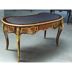 an ornately decorated table with leather top