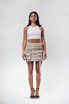 Get ready to amp up your streetwear game with our freshest creation - introducing the ACS Mini Cargo Skirt! We've poured our techwear and streetwear passion into this beauty, and we can't wait for you to experience it firsthand. *Intricate Design, Striking Look: Dive into the dynamic front design, featuring cargo pockets and hanging straps. This combination crafts a unique silhouette that effortlessly catches attention, making each step a statement. *Beige Colorway: Elevate your wardrobe with th Y2k Fitted Skirt For Streetwear, Y2k Style Fitted Cargo Skirt For Streetwear, High Waist Summer Skort For Streetwear, High Waist Skort For Summer Streetwear, Cotton Fitted Skirt For Streetwear, Fitted Cotton Skirt For Streetwear, Fitted Mini Length Bottoms For Streetwear, Streetwear Bottoms With Pockets In Mini Length, Trendy High Waist Skort For Streetwear