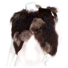 The Yves Saint Laurent Avant Garde Multi-Fur Patch Vest from the 1980s is a stunning statement piece that celebrates the artistry and extravagance of vintage fashion. Crafted from an exquisite blend of various furs, including goat, lamb, and fox, this vest showcases a harmonious mix of rich brown shades, creating a unique texture and depth. Its cropped silhouette is both flattering and versatile, with a hook closure option at the top that allows for your preferred styling. This rare gem pairs ef Avant Garde Accessories, Patch Vest, Azzedine Alaïa, Chanel Skirt, Purple Blazer, Reversible Skirt, Azzedine Alaia, Jeans Levis, Black Tweed