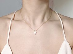 This stunning necklace features a unique cross-shaped baroque pearl pendant, which is sure to make a statement. The irregular shape of the pearl gives it a natural, organic look, while the lustrous surface reflects light beautifully. The pearl is suspended from a delicate make of 14k gold filled, adding to the elegance of the piece. Perfect for both casual and formal occasions, this necklace is a versatile addition to your jewelry collection. Whether you wear it to work or to a special event, it will add a touch of sophistication and individuality to your outfit. This cross-shaped baroque pearl necklace also makes a thoughtful and unique gift for someone special.  Material: Cross-shaped Baroque Freshwater Pearl, 14k gold plated chain  Length: 15 inches. Simply leave a message at checkout s Pearl Chain Cross Pendant Necklace Gift, Gift Pearl Chain Cross Pendant Necklace, White Cross Necklace With Pearl Pendant, Elegant White Cross Necklace With Adjustable Chain, White Cross Necklace With Clavicle Chain, White Cross Pendant Necklace With Clavicle Chain, Elegant White Cross Necklace Pendant, Elegant White Cross Pendant Necklace, Gold Cross Necklace With Pearl Pendant