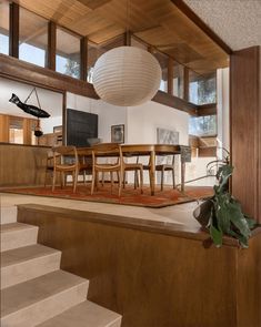 a dining room table with chairs and a rug on the floor in front of it