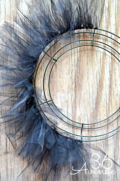 a wreath made out of feathers on top of a wooden table with the word above it