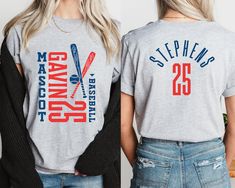 two women wearing matching t - shirts with baseball bats on them