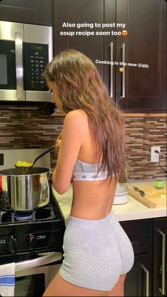 a woman standing in front of an oven preparing food