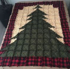 a quilted christmas tree sitting on top of a bed