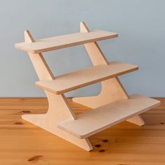 a three tiered wooden shelf sitting on top of a hard wood floor