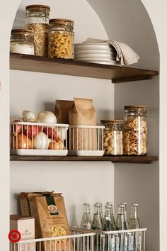 a kitchen shelf filled with lots of food and drinks next to a calendar on the wall