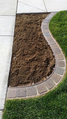 a brick walkway in the middle of some grass and dirt on the side of a sidewalk