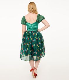 This charming swing dress is crafted in a green satin-like fabric with a green skirt that dances with Christmas lights throughout and features dazzling lights that shine through the chiffon! Complete with a back zipper and elastic short sleeves..Available in sizes XS-5X while supplies last..Batteries not included | Unique Vintage Light Up1950S Green Christmas Lights Print Sweetheart Dress | Size Xlarge/14 Festive Green Fitted Holiday Dress, Festive Fitted Green Holiday Dress, Fitted Green Holiday Dress, Green Short Sleeve Dress For Holiday, Green Short Sleeve Christmas Dresses, Short Sleeve Holiday Dress For Christmas Party, Green Dress For Costume Party, Green Christmas Lights, Vintage Christmas Dress