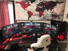 a computer desk with three monitors and two keyboards on it in front of a map