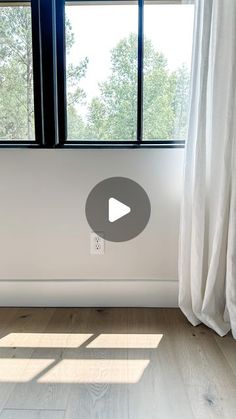 an empty room with white curtains and windows