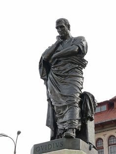 a statue of a man standing next to a building