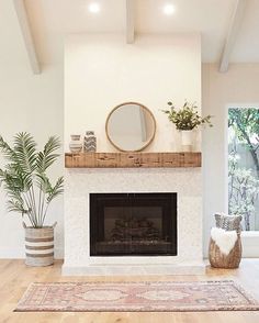 a living room with a fireplace and potted plants