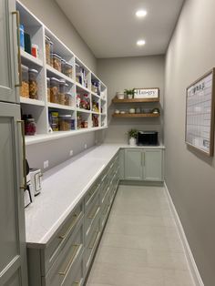 a kitchen with white counter tops and gray cabinets