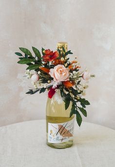 a bottle filled with flowers sitting on top of a table