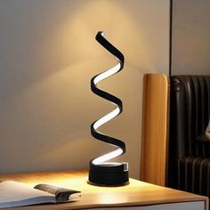 a lamp that is sitting on top of a table next to a book and chair