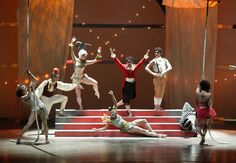 the dancers are performing on stage with their arms in the air and one person laying down