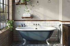 a white bath tub sitting in a bathroom next to a window