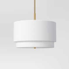 a white light hanging from a ceiling fixture with a gold bar at the top and bottom