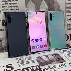 three samsung foldable phones sitting next to each other on top of a news paper