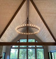 a living room filled with furniture and a large window covered in lightening fabric on the ceiling