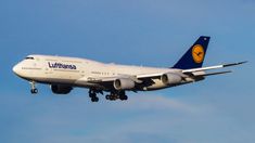 a lufthansa airplane is flying in the sky with it's landing gear down