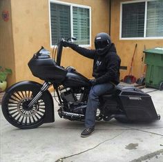 a man riding on the back of a black motorcycle