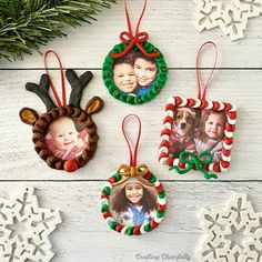 three christmas ornaments are hanging on a white wooden table with snowflakes and evergreen branches