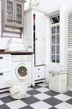 a white washer and dryer in a room with black and white checkered flooring