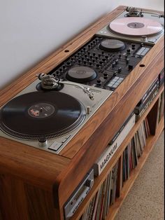 a record player sitting on top of a wooden shelf next to a wall mounted cd player