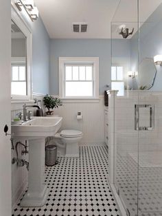 a bathroom with black and white tile flooring and walls, along with a walk in shower