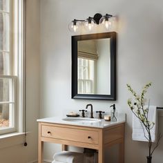 a bathroom with a sink, mirror and window