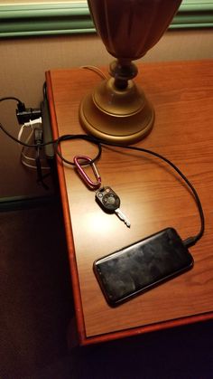 an electronic device is plugged into the charger on top of a wooden table