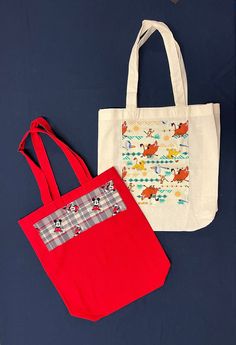 One of each Tote Bag design is available, featuring various cartoon characters: Lion King, Daniel Tiger, Minnie and Mickey Mouse together on plaid, Bluey, Sonic and others. All totes 100% cotton, except Aqua which is Polyester.  Size: 13.5" x 13.5" x 4" (4"gusset) Washable in cool or cold water, hang dry or tumble dry low. Iron on low or medium setting.  Details: Minnie Mickey Plaid, 13.5" x 13.5" x 4"  Red tote bag shown in photo. Also available in other colors: Ivory (cream) color tote bag or Cartoon Character Print Bags For Everyday Use, Fun Multicolor Bag With Character Print, Fun Everyday Bags With Cartoon Print, Fun Cartoon Print Bags For Everyday Use, Playful Multicolor Bags With Character Print, Playful School Bag With Character Print, Playful Character Print Multicolor Bag, Playful Multicolor Character Print Bags, Themed Rectangular Bags For Daily Use