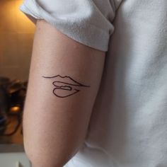 a woman's arm with a tattoo on it that has a line drawing of her lips