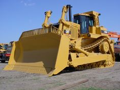 a large yellow bulldozer sitting in the dirt