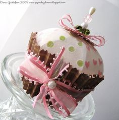 an ornament is sitting on top of a glass bowl filled with chocolates