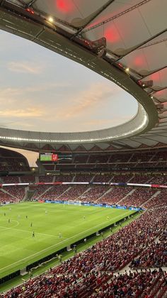 a stadium filled with lots of people watching a soccer game on the field in front of an audience