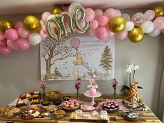 a table topped with lots of desserts and balloons