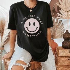 Relaxed Fit Smiley Face Top For Loungewear, Smiley Face Top For Loungewear, Black Crew Neck T-shirt With Smiley Face, Black Smiley Face Crew Neck T-shirt, Black Crew Neck Top With Smiley Face, Black Smiley Face Crew Neck Top, Cute T-shirt With Slogan For Lounging, Everyday Relaxed Fit Top With Smiley Face, Relaxed Fit Smiley Face Top For Everyday