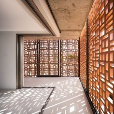 an empty room with wooden partitions on the wall and potted plant in the corner