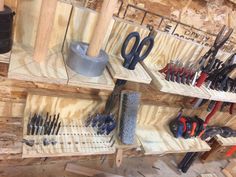 tools are lined up on wooden shelves in a workshop with hammers and pliers