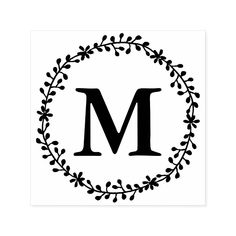 the letter m is surrounded by a wreath