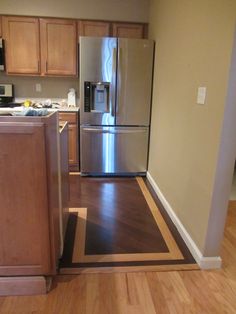 a metallic refrigerator freezer sitting inside of a kitchen