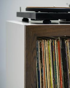 a record player is sitting on top of a shelf full of vinyl records and cds