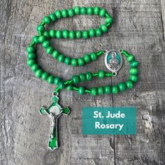 "This Green St Jude Rosary is crafted with Green Wooden beads, featuring an Italian made stunning green enamel centerpiece of Saint Jude. The centerpiece of this handmade Catholic cord rosary is silver oxidized and \"Pray for Us\" is engraved on the back. The crucifix is die-cast for exceptional detail and features an inlaid St. Benedict medal front and back with a beautiful green enamel background.  Saint Jude Wooden Rosary Details: *8mm Green Wooden Beads *1 1/8\" St Jude Green Enamel Centerpi Adjustable Green Rosary With Round Beads, Green Beaded Spiritual Rosary, Green Beaded Rosary, Handmade Green Rosary, Green Beaded Rosary With Round Beads, Spiritual Green Necklace With Wooden Beads, Green Spiritual Necklace With Wooden Beads, Green Rosary With Round Beads As Gift, Handmade Green Rosary As A Gift