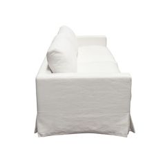 a white couch sitting on top of a white floor next to a pillow and blanket