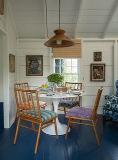 a dining room with blue floors and white walls