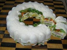 there is a very large sandwich made out of bread on the table with black and white checkered flooring