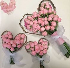 three bouquets of pink roses are arranged in the shape of a heart and tied with twine